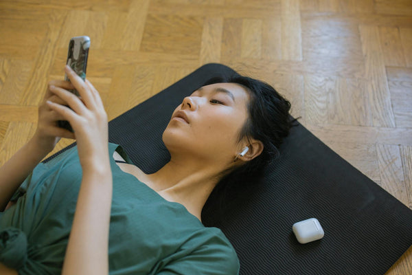 Om care poartă AirPods Pro în ureche, zâmbind, pe fundal albastru